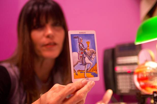 Michelle, who specializes in Tarot and palm reading, hold up ...